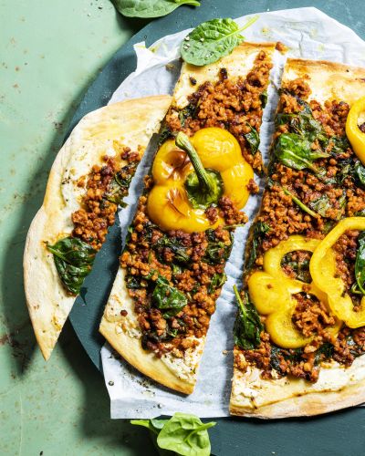 Middle Eastern-style flatbread pizza with spinach and peppers