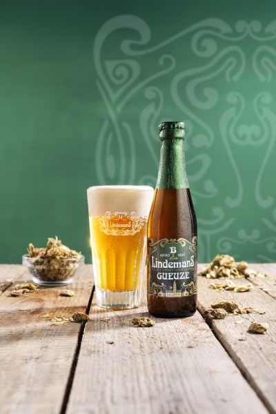 Lindemans Gueuze 25cl beer bottle and glass on wood table