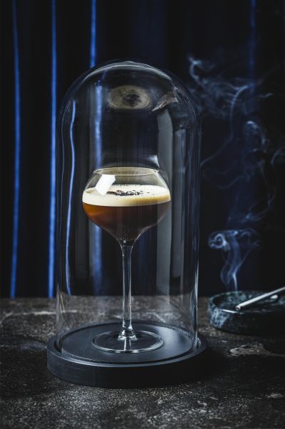 Espresso martini served under a smoked glass dome
