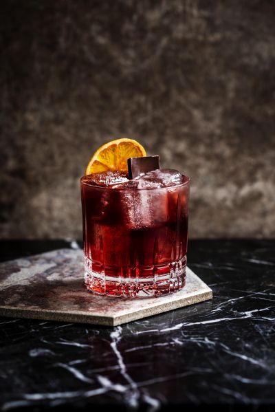 Negroni cocktail with orange garnish on a marble table