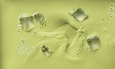Alpro matcha drink with ice cubes, top-down texture shot