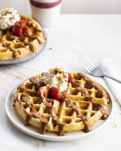 Waffles with Biscoff sauce, strawberries and whipped cream