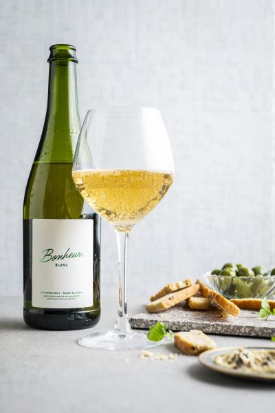 Just Bonheur white aperitif bottle and glass with snacks