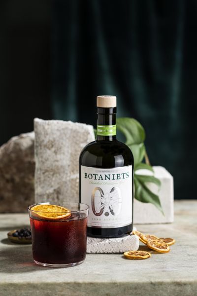 Botaniets negroni cocktail with the gin bottle and dried orange
