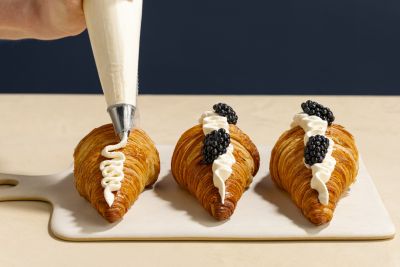 Croissants decorated with piped cream and berries